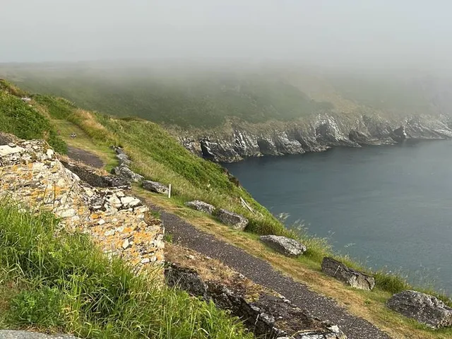 A green and flagstick at Old Head, with a pot bunker in front.