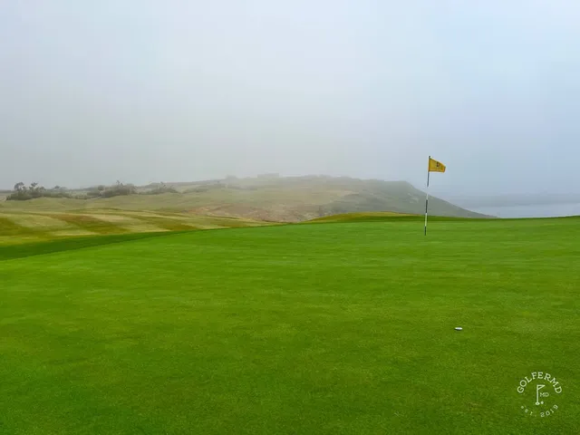 A fairway and green at Old Head, with the cliff wrapping the right side.