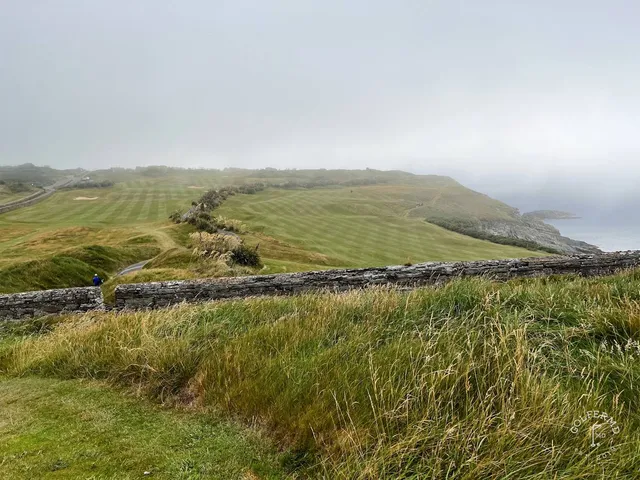 A green and flagstick at Old Head, seen from well back on the fairway.