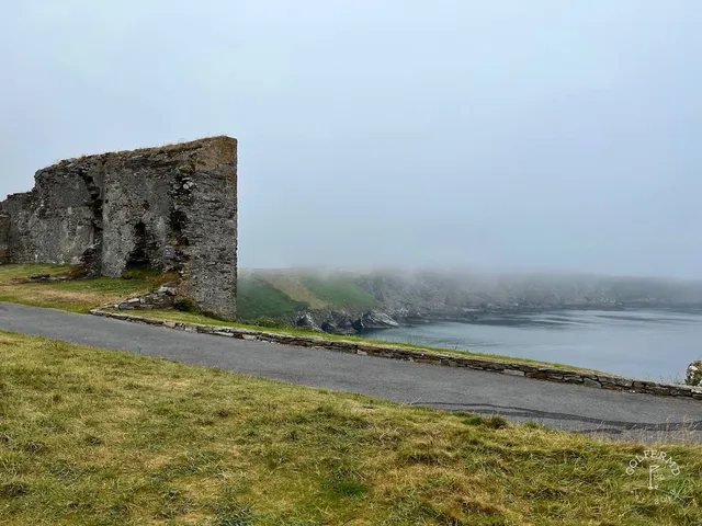 A green and flagstick at Old Head, with the green sloping toward the cliff.
