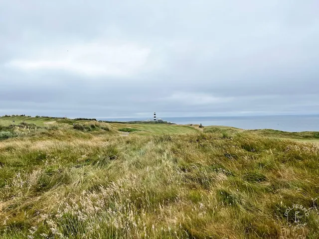 A golfer putting at Old Head, with the Atlantic at the edge of the green.