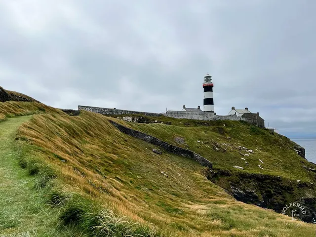 A green and flagstick at Old Head, with the headland and the ocean in one view.