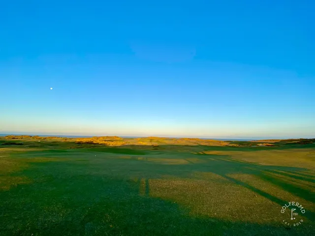 A wide view at Old Macdonald, the green in the dunes and the ocean in the distance.