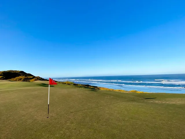 A fairway at Old Macdonald with a bunker on the left and the ocean ahead.