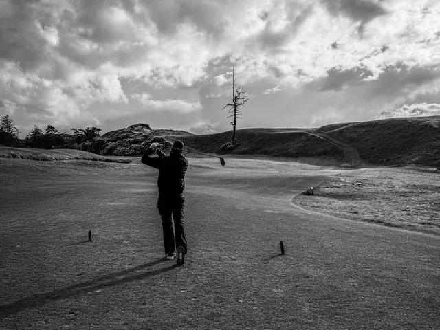 A green at Old Macdonald guarded by a bunker, with the Pacific behind the flagstick.