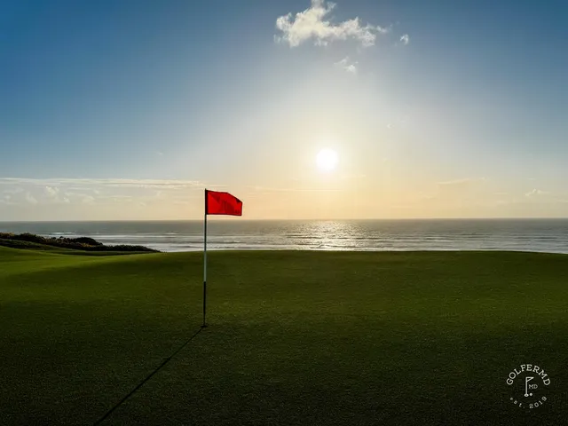 A green and flagstick at Old Macdonald seen from the fairway, with the ocean filling the background.