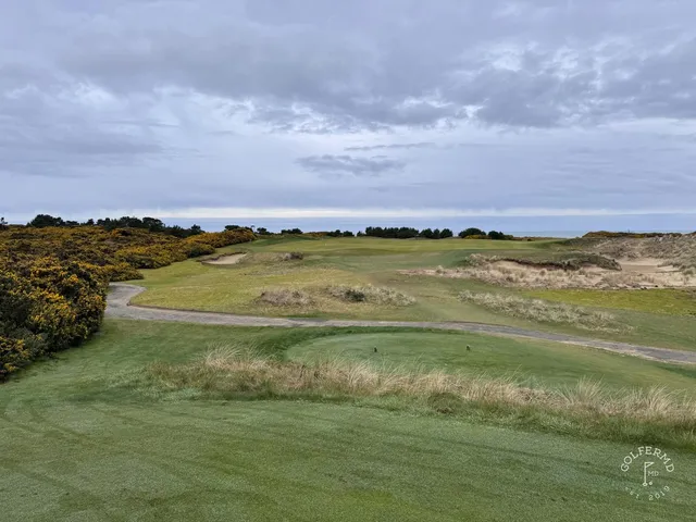 A green and flagstick at Old Macdonald, sand short of the hole and the ocean beyond.
