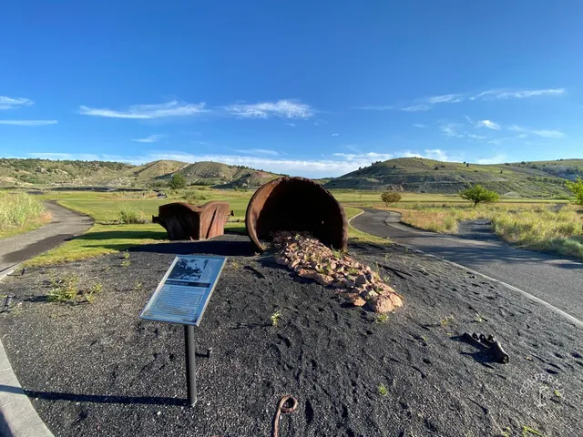 A wide fairway at Old Works, with black bunkers and the mountains on the horizon.