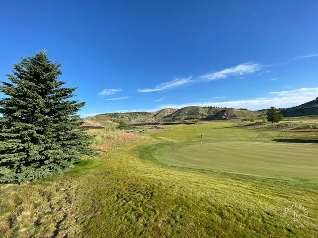 A green and flagstick at Old Works, seen from the fairway, with a black bunker short of the green.