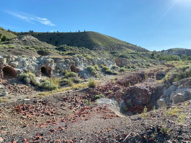 A wide view across Old Works, with fairway, black sand, and the mountains.