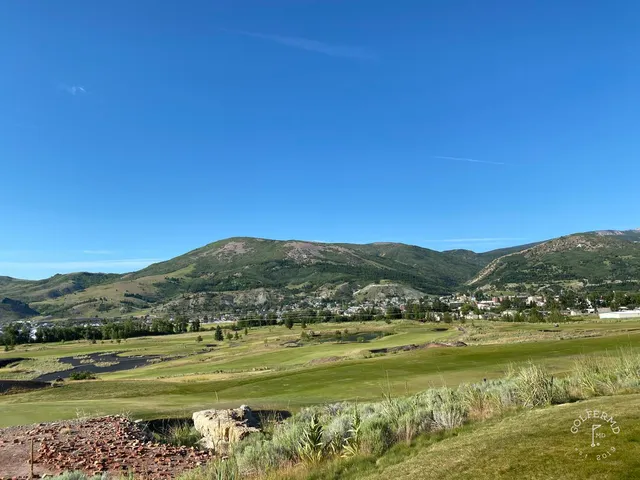 A group of golfers at Old Works, with the course and the mountains behind them.