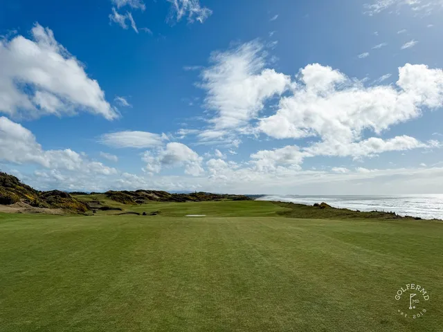 A close view of a flagstick at Pacific Dunes, with the ocean filling the background.