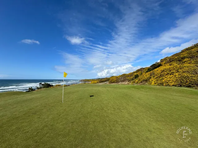 A fairway at Pacific Dunes with a bunker in the foreground and the water beyond.