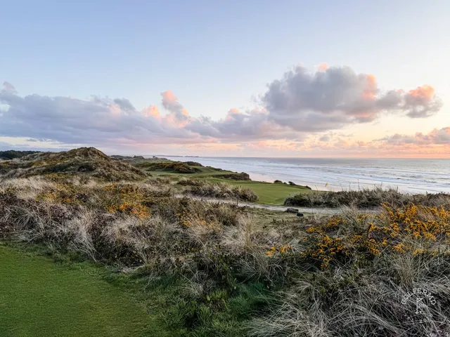 A green and flagstick at Pacific Dunes, seen from a rise above the hole.