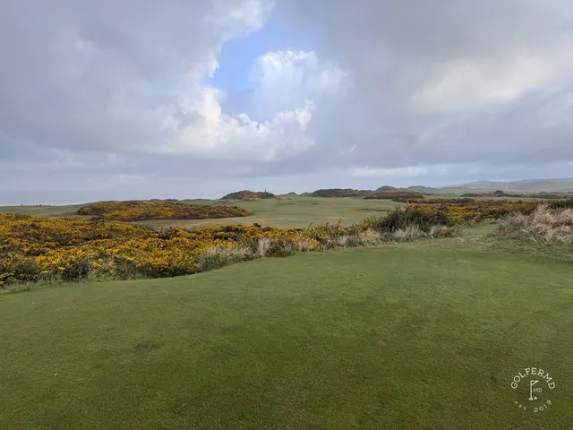 A wide fairway at Pacific Dunes dropping toward the ocean.