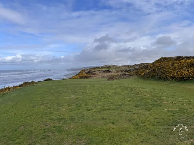 A fairway at Pacific Dunes, with a bunker along the hole and the ocean beyond.