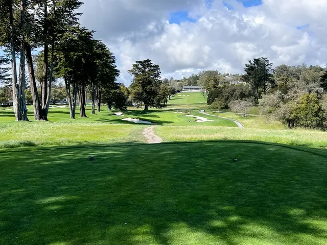 A fairway running toward a green at Pasatiempo Golf Club, with trees on both sides.