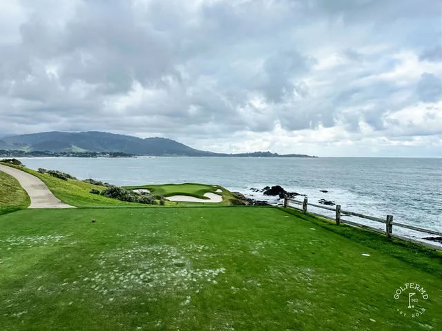 A fairway bordered by cypress trees at Pebble Beach Golf Links, with the ocean beyond.