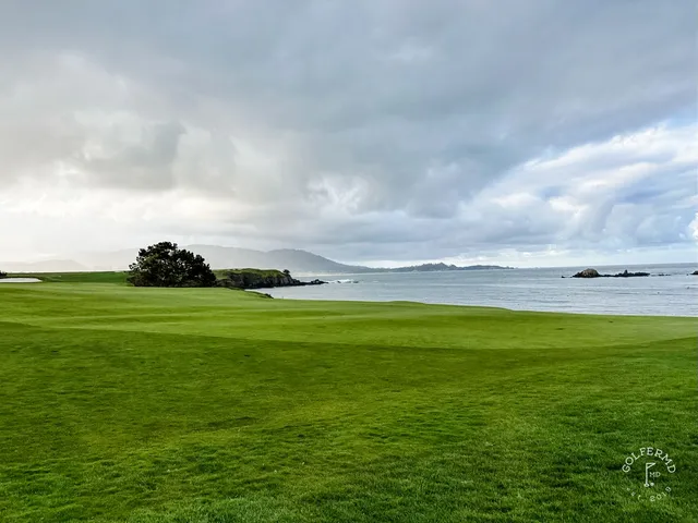 A narrow fairway between cypress trees leading to the ocean at Pebble Beach Golf Links.