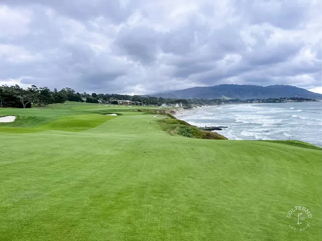 A fairway and green beside the ocean at Pebble Beach Golf Links, with cypress trees along the hole.