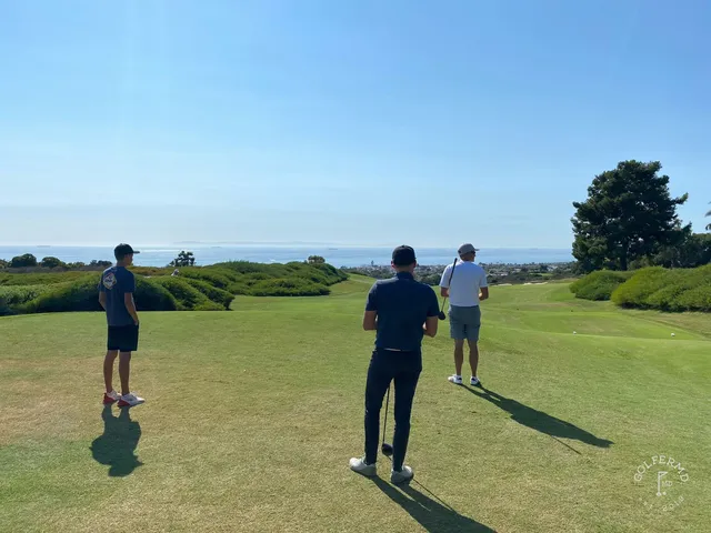 A green and flagstick on the edge of the bluff at Pelican Hill Ocean North Course, with the ocean below.