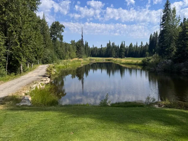 A group of golfers at Priest Lake, with the lake and forest behind them.