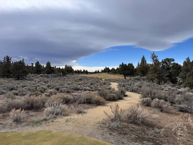 A golfer hitting a shot at Pronghorn, with the desert fairway ahead.