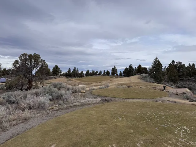 A fairway at Pronghorn lined with juniper, running toward the hills.