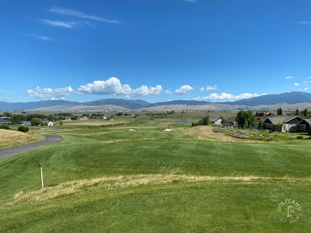 A fairway at The Ranch Club running through the valley, with mountains behind the hole.