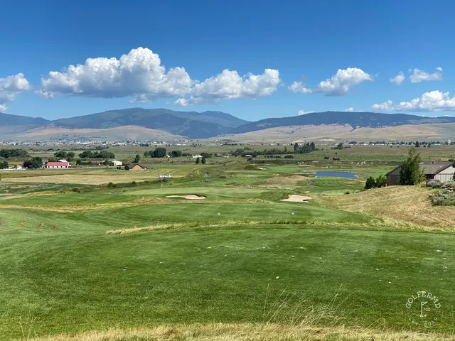 A green and flagstick at The Ranch Club, with a bunker in front and the mountains beyond.