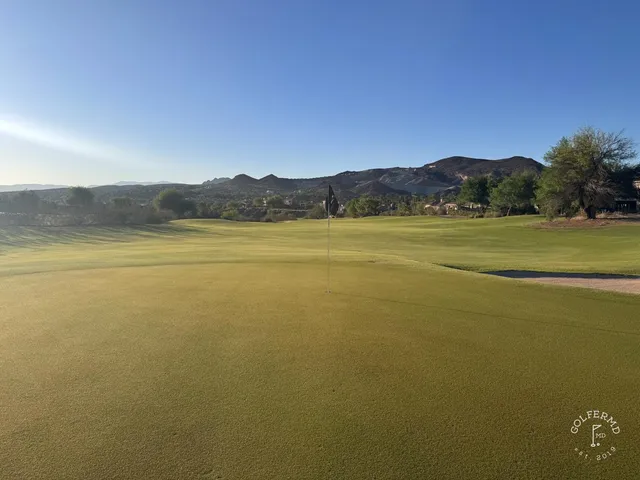A golfer hitting a shot at Reflection Bay, with the lake and the fairway ahead.