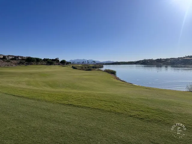 A golfer putting on a green at Reflection Bay, with the lake beyond the hole.