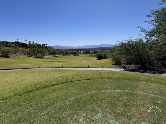 A fairway and green at Reflection Bay, with a bunker in the foreground and the lake beyond.