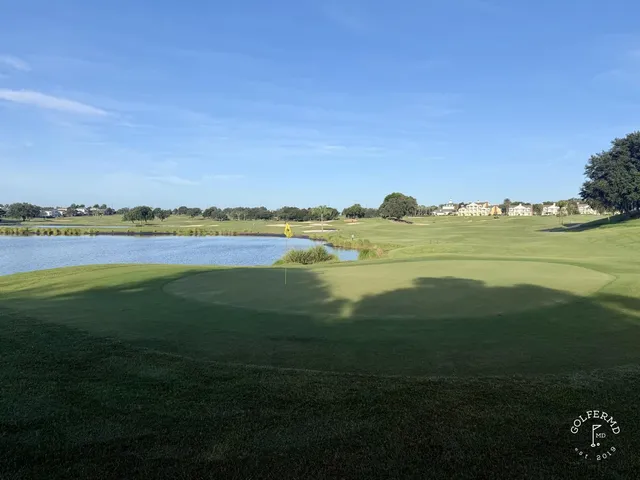 A wide fairway at the Palmer Course with a sand bunker on the left and a pond on the right.