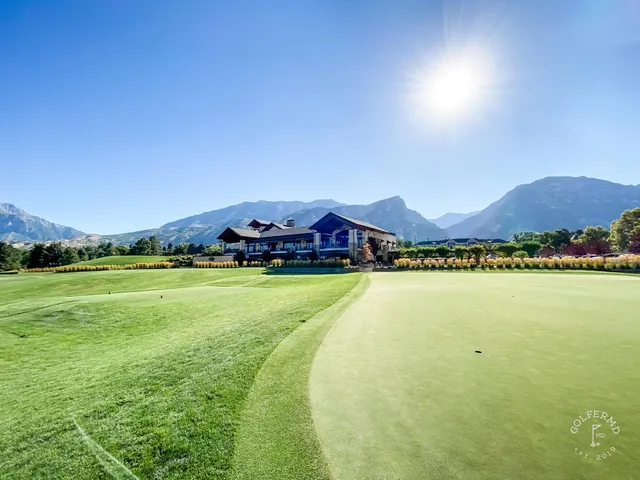 A green and flagstick at Riverside Country Club, with a bunker in front and the mountains beyond.