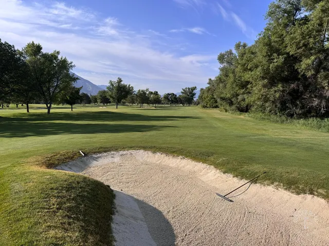 A wide fairway at Riverside Country Club, with the Wasatch Mountains in the distance.