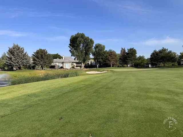 A fairway at Riverside Country Club bending toward a green, with the mountains beyond.