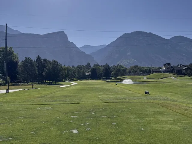 A close view of a flagstick at Riverside Country Club, with the mountains behind the green.