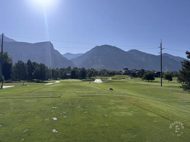 Another close view of a green and flagstick at Riverside Country Club, with the mountains filling the background.