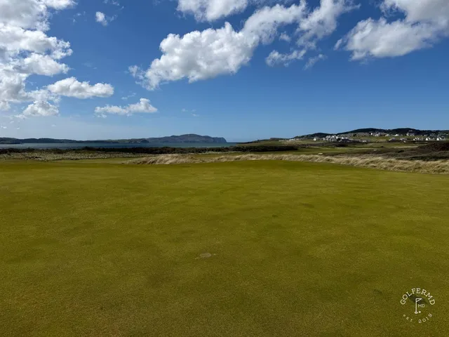 A green and flagstick on the Sandy Hills, seen from the fairway, with the ocean beyond.