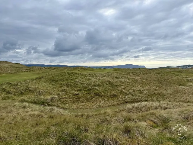 A wide fairway on the Sandy Hills, with the dunes and the mountains in the distance.