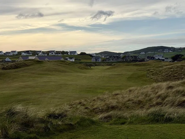 A wide view across the Sandy Hills, with fairway, dunes, and Sheephaven Bay.