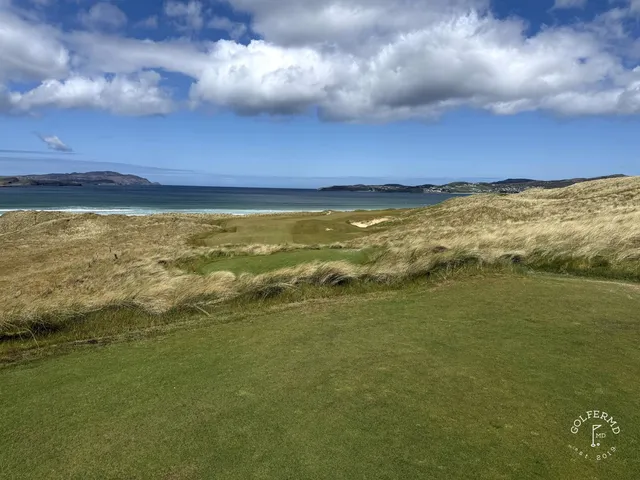 A group of golfers on St. Patrick's, with the ocean behind them.