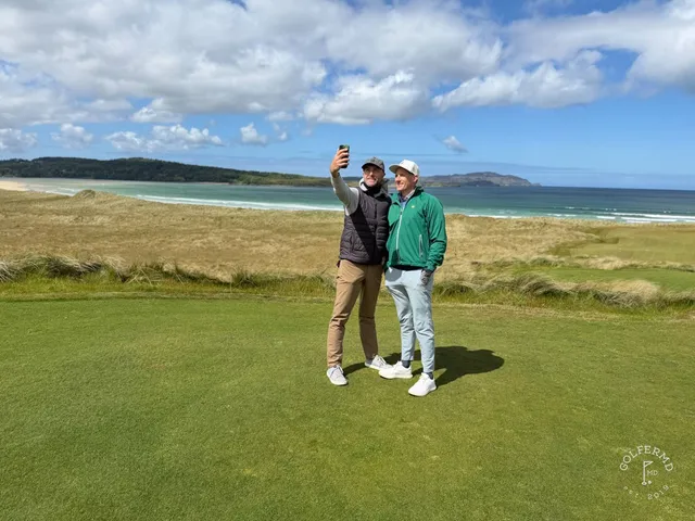 A close view of a flagstick on St. Patrick's, with the bay behind the green.