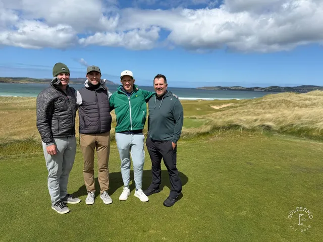 A green and flagstick on St. Patrick's, with a deep bunker in front and the water beyond.