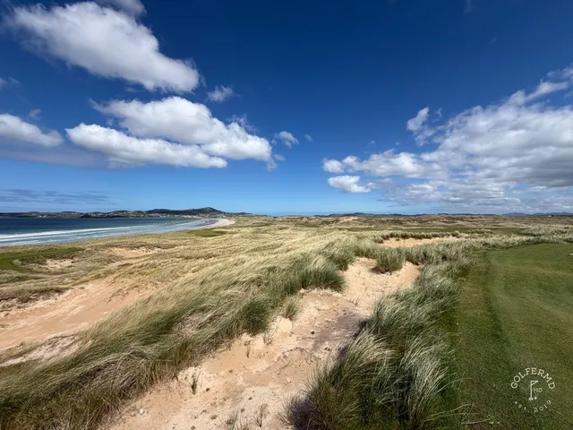 A fairway on St. Patrick's with a bunker in the foreground and the bay beyond.