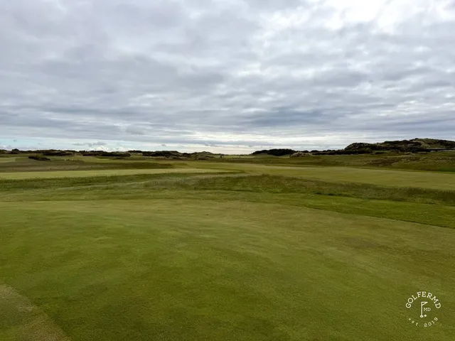 Golfers on a tee on the Annesley Links, with the bay behind them.