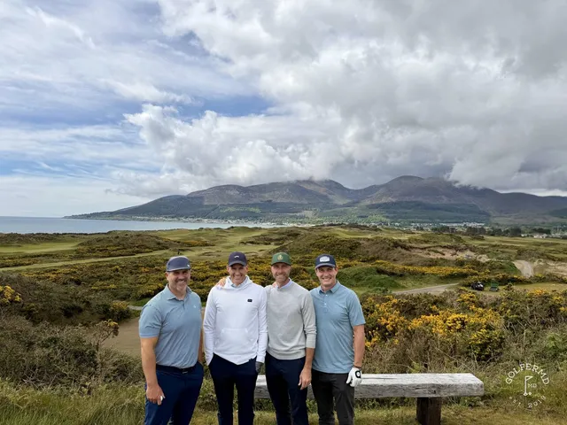 Golfers standing on a tee on the Annesley Links, the fairway and the mountains in front of them.