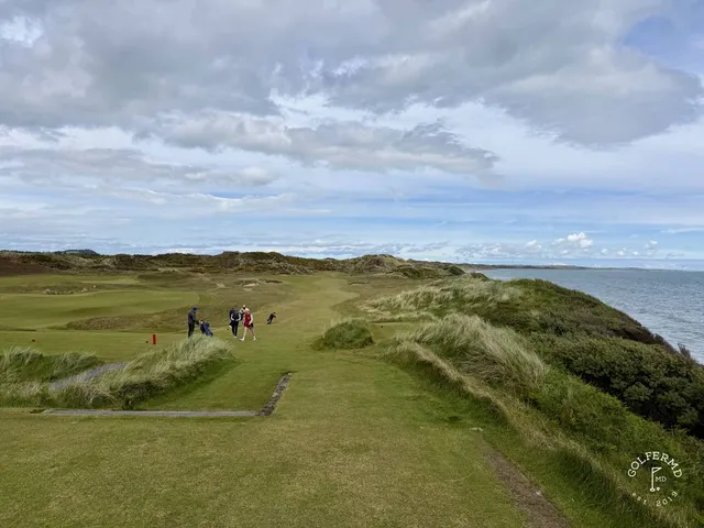 A green at Royal County Down set in the dunes, the flagstick against the mountains.