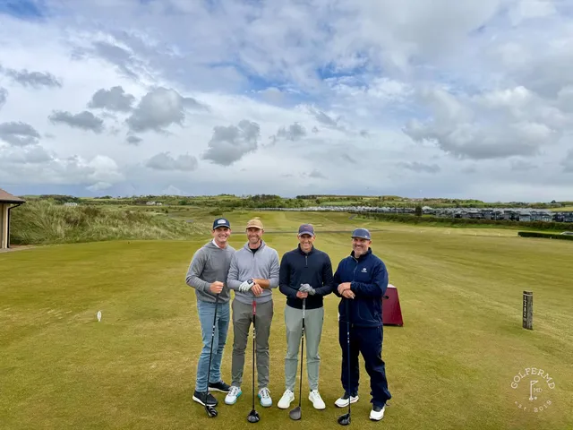 A green and flagstick at Royal Portrush, with a bunker in front and the ocean behind the hole.